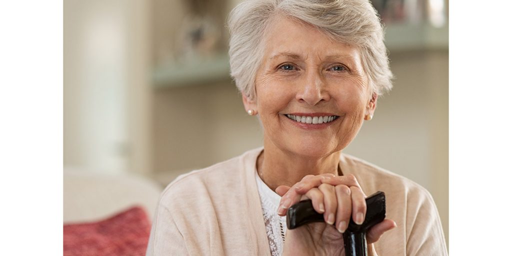 Senior woman simling and holding a cane