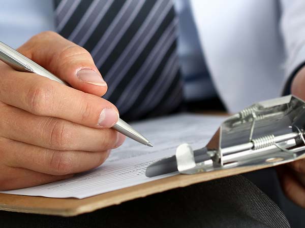 man completes form on clipboard