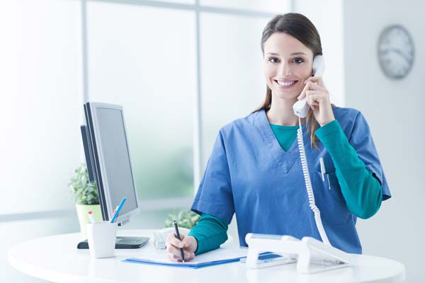smiling woman answers phone in healthcare setting