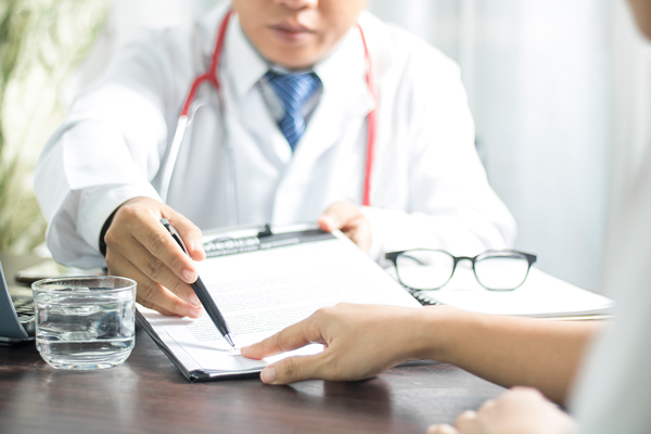 doctor points to form on clipboard